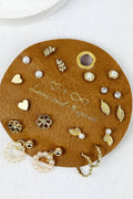 Round brown leather jewelry tray with various earrings on a white background
