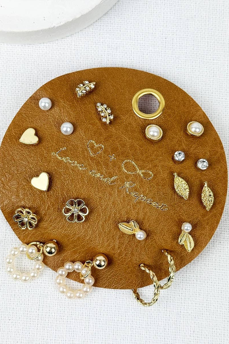 Round brown leather jewelry tray with various earrings on a white background
