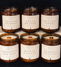 Six amber glass jar candles from 1971 Candle Co. arranged in two rows on a dark background.