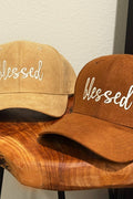 Two hats with 'blessed' text on a wooden surface