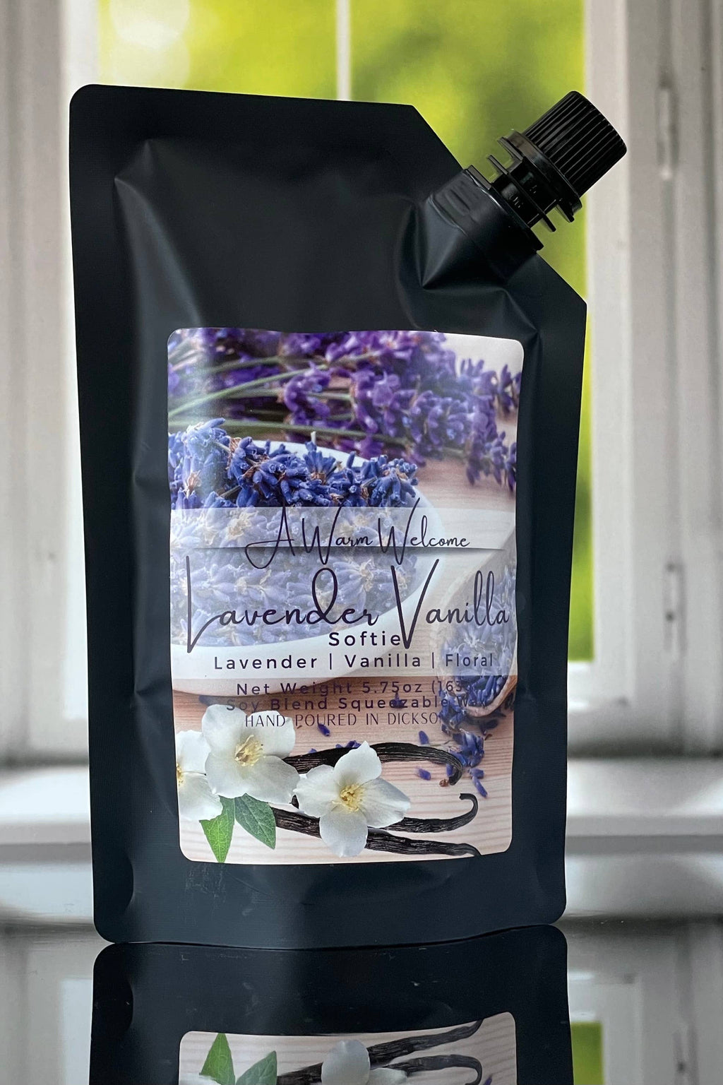 A black stand-up pouch of Altona's Vanilla Lavender Softie soap, featuring a lavender and vanilla graphic label, set against a blurred window background.