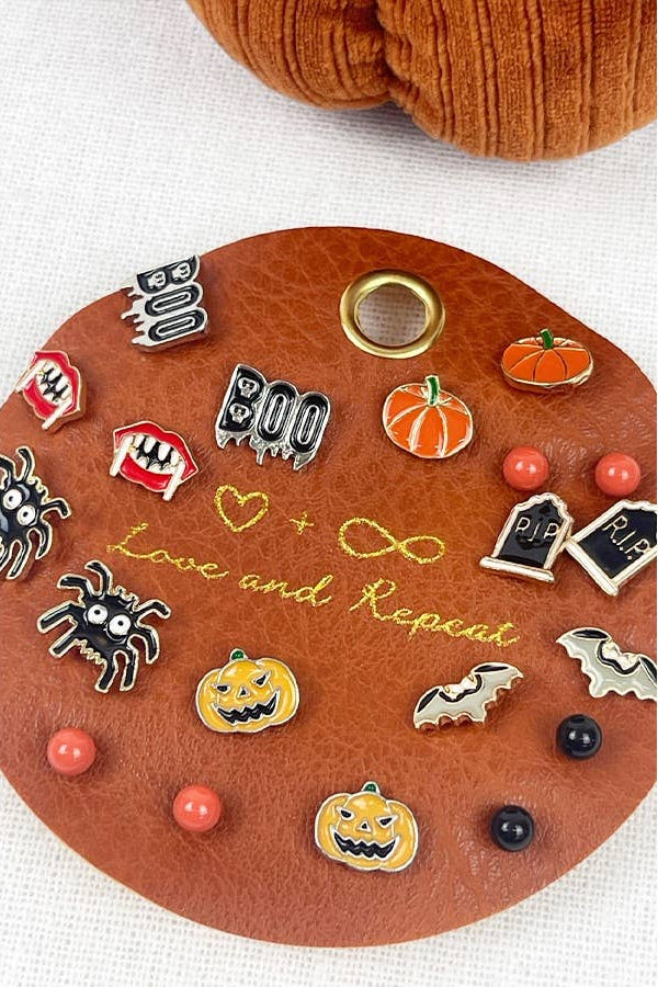 Collection of Halloween-themed pins on a decorative board with a pumpkin design.