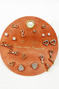 Collection of gold and pearl earrings on a round leather card with 'Love' and 'Pearl' text.